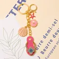 Detail of gold-tone beach keychain with rhinestone flip-flop, shell, and starfish charms. - Color 2