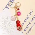 Detail shot of beach-themed keychain with flip-flop and shell charms in golden finish. - Color 3