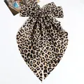 Elegante oversized haarclip met luipaardprint strik en vintage esthetiek op wit - Haarclip Met Geel Lintje Met Luipaardprint