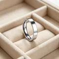 Primo piano di un anello a fascia in acciaio inossidabile argento in un portagioie - Lunetta Liscia Con Finitura A Specchio Larga 4 Mm / Misura 5