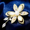 Elegante broche floral con perla y circonita sobre un fondo de seda azul intenso - B624