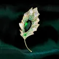 Elegante broche de hoja dorada con circonitas verdes y claras microengastadas - B466