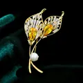 Exquisito broche de hoja chapado en oro con circonitas amarillas brillantes y una perla blanca - B578
