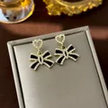 French retro bow-knot earrings with black enamel and heart-shaped pearls in a golden finish. - 77# Hollow Heart-shaped Pearl Bow Earrings