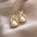 Elegant gold cross earrings with triangular cream pearls displayed on satin fabric - 96# Cross X-shaped Pearl Stud Earrings