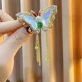 Luxuriöse Schmetterlingsbrosche mit Zirkonsteinen und eleganten goldenen Quastenketten. - B1692