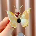 Eleganter goldener Schmetterlings-Brosche mit schillernden Flügeln und schwarzem Stein - B1747 Huangbei