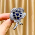 Eleganter silberner Blumenanstecker mit dunkelblauen Saphiren und weißen Zirkonia - B442