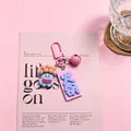 Close-up of a cute blue monster resin keychain with a pink "Hot Pot" tag and bell - Hot Pot