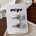 Set of two silver metallic hair clips with light blue ribbon bows on white card - Bowknot BB Hair Clips