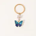 Élégant porte-clés doré avec pendentif papillon en émail bleu et petite fleur rose - Papillon bicolore bleu