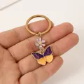 Porte-clés élégant avec breloque papillon violet et orange et pendentif fleur délicat - Papillon bicolore jaune et violet