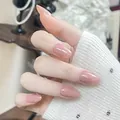 Close-up of short oval press-on nails with nude pink gradient on a hand. - Boxed Set / Nude Pink