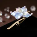 Detailed macro view of elegant water lily enamel brooch with iridescent petals and gold finish - Purple
