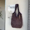 Handgemaakte hol geweven strooien schoudertas in donkerpaars met decoratieve kwastjeshanger detail - Paars