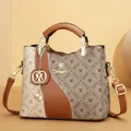 Detailed view of fashionable large capacity tote bag with brown printed pattern and gold logo - Brown