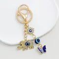 Macro view of gold elephant and butterfly charm evil eye keychain accessory detail - Gold Elephant Butterfly Motif (9693)