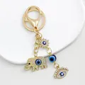 Exquisite close-up of a golden keychain featuring rhinestone elephant and blue evil eye charms - Gold Elephant Sun Eye Motif (9694)