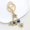 Close-up of golden elephant and evil eye charms on a sparkling rhinestone keychain - Gold Elephant Heart Butterfly Motif (9692)