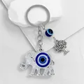 Detail shot of a silver elephant keychain with a blue evil eye bead and tree charm - Silver Elephant Tree of Life Motif (6272)