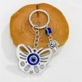Detail view of silver butterfly keychain featuring blue evil eye and tree of life charms - Silver Butterfly Tree of Life Motif (7524)