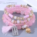 Dettaglio ravvicinato del set di braccialetti di perline rosa con ciondolo HAPPY e nappa - Rosa