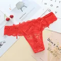 Detail of bright red lace thong featuring delicate floral patterns and side bows. - One Size / Red