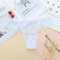 Close-up view of elegant white lace jacquard thong with intricate floral patterns - One Size / White