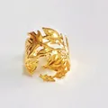 Dettaglio di un portatovaglioli in metallo dorato con design a foglia - Oro