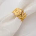 Vista detallada de un servilletero de hoja dorada que muestra texturas en una servilleta blanca - Dorado