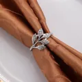 Détail d'un rond de serviette en forme de feuille argentée avec des strass brillants - Style Zircon Blanc / Argent