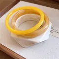 Détail d'un ensemble de trois bracelets en résine aux formes géométriques et motifs marbrés - Ensemble trois pièces / Blanc & Jaune Ambré (Lot de 3)