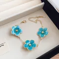 Close-up view of a blue enamel flower bracelet with an elegant gold-plated chain detail - Bracelet / Blue