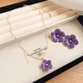 Detailed view of the purple enamel flower necklace and stud earrings in a luxury jewelry box - Necklace + Earrings Set / Purple