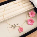 Detailed view of a pink enamel flower pendant necklace and matching stud earrings set - Necklace + Earrings Set / Pink
