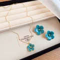 Detail view of blue enameled flower pendant necklace and stud earrings set - Necklace + Earrings Set / Blue