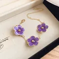 Elegant gold adjustable chain bracelet featuring three vibrant purple enamel flower charms - Bracelet / Purple