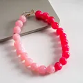 Primer plano de cuentas de acrílico marbreado en un collar degradado rosa dopamina - Rosa