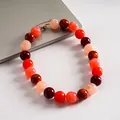 Vista detallada de primer plano de collar de acrílico con cuentas jaspeadas rojas y rosas. - Rojo-Naranja-Rosa
