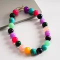 Primer plano de cuentas de acrílico jaspeado en un collar con texturas vibrantes. - Multicolor