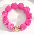 Close-up of hot pink acrylic square beads with white swirl and gold bead on bracelet - Rose Red (11255)