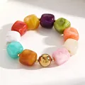 Close-up detail of colorful marbled acrylic cube beads and a gold sphere on a bracelet - Colorful (11250)