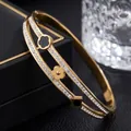 Close-up of elegant double-band gold bangle with lucky clover charms and crystals. - Clover Rhinestone Style (41-A-9) / Gold