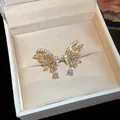 Close-up of gold-plated butterfly ear cuffs with sparkling zirconia stones in a gift box. - Butterfly Waterdrop / Gold