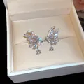Detailed close-up of butterfly wing ear clips featuring sparkling zircons and waterdrop charms - Butterfly Waterdrop / Silver