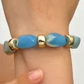 Detailed close-up of blue and white swirled resin beads on a gold-accented bracelet - Bracelet Only (12054) / Gold