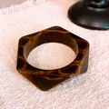 Close-up of vintage geometric resin bangle with elegant brown and gold marbled pattern - Coffee Polygon
