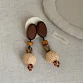 Close-up detail of vintage Bohemian style straw braided and wooden pendant drop earrings - Spherical Straw Woven Style (3#) / Brown