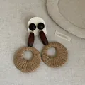 Detail view of bohemian earrings featuring hand-woven straw rings and dark wooden beads - Round Straw Woven Style (5#) / Brown