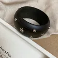 Dettaglio ravvicinato di un bracciale rigido in resina verde scuro con stelle e borchie argento - Bracciale Rigido Lusso Leggero / Borchia Stella Nero Argento